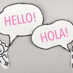 characters saying hello in english and hola in spanish