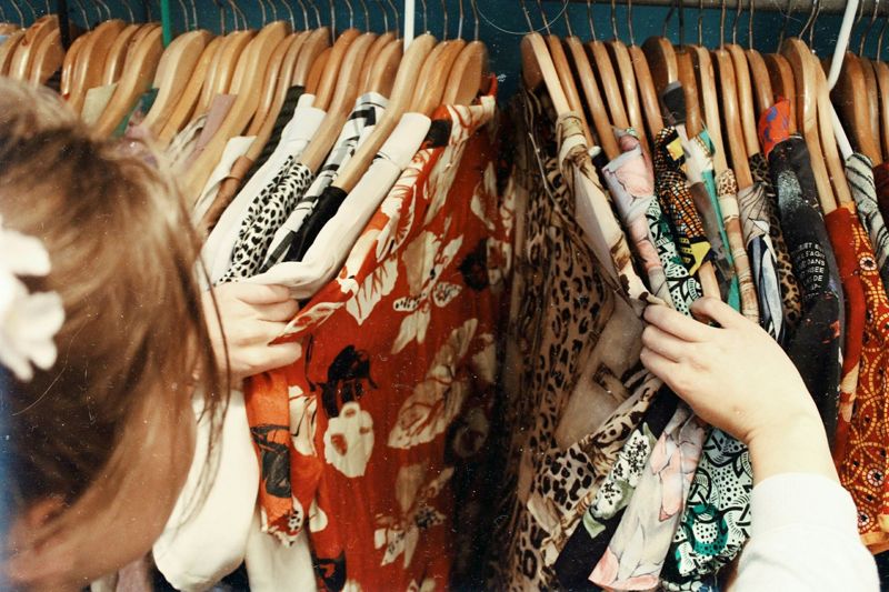 woman browsing clothes rack in shop