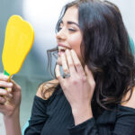 Woman checking dental implants in mirror