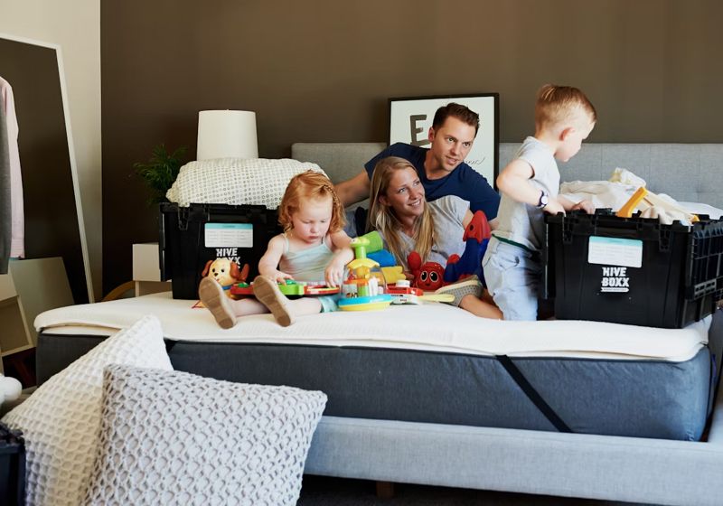 parents and children on bed packing boxes