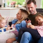 family together on coach all on screens