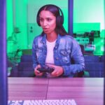 woman playing video game with controller and headset
