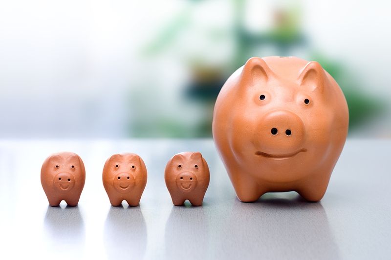 conceptual view of compound interest - big piggy-bank and the small ones